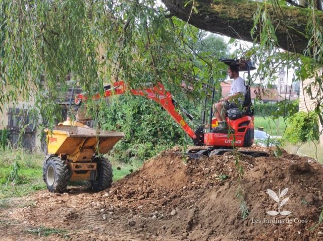 Mini-pelle et dumper en cours de terrassement dans un jardin